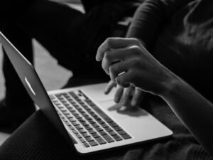 grayscale photo of person using MacBook