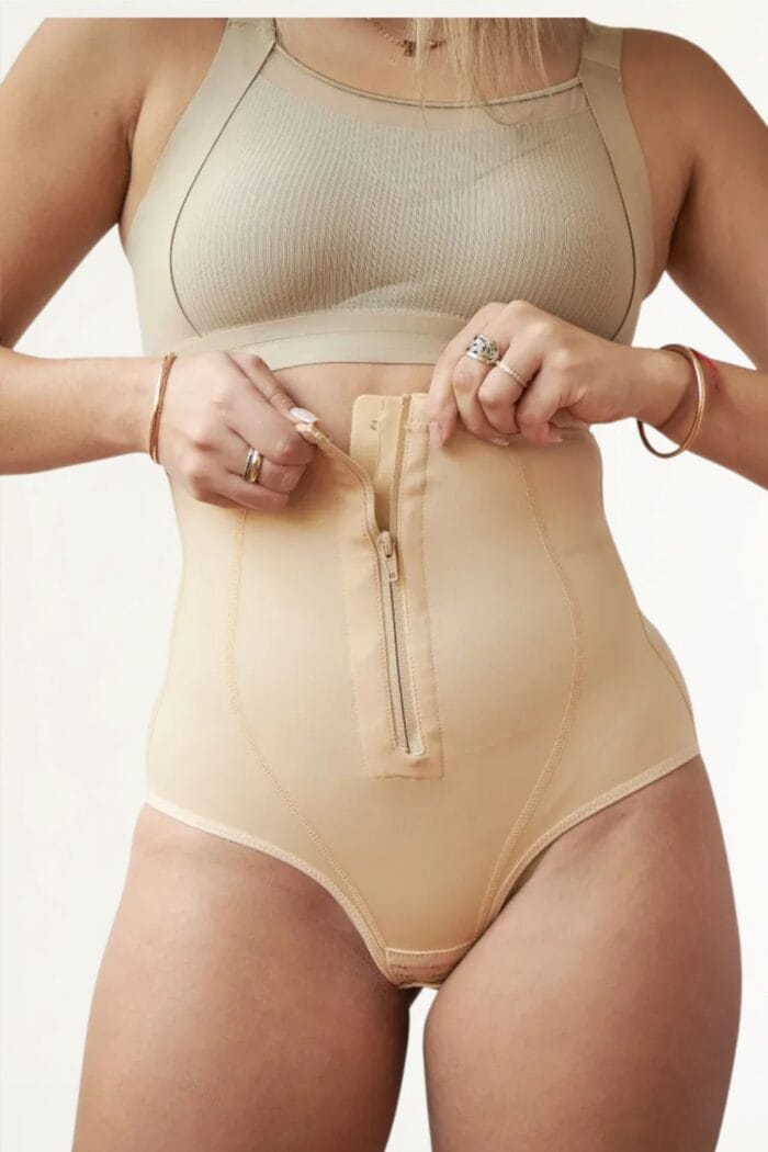 Detalle frontal de faja bombacha beige con cierre ajustable en el abdomen