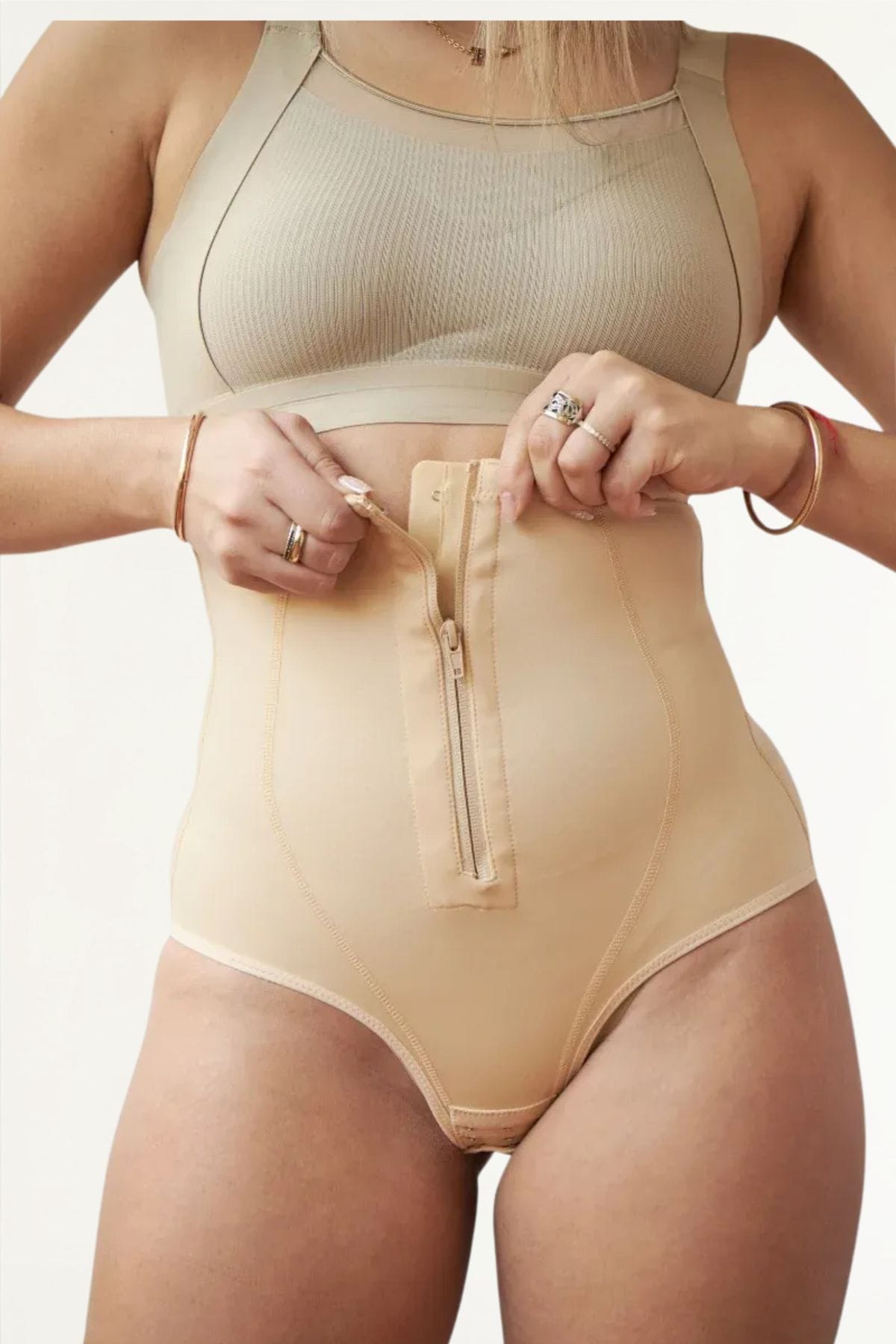Detalle frontal de faja bombacha beige con cierre ajustable en el abdomen